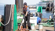 A dekhand with King County Water Taxi works at Pier 50.
