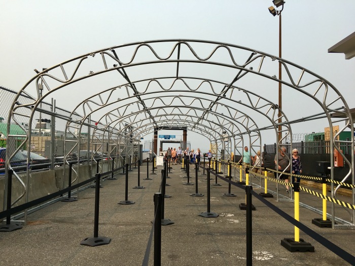King County Water Taxi riders disembarking from West Seattle walk under metal frames that will soon support a canopy to protect riders from the elements.