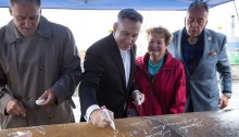 King County Executive Dow Constantine signs a steel pile that will be used to help support the future Colman Dock. To the left is Washington Gov. Jay Inslee, and to the right are state Rep. Judy Clibborn and Bardow Lewis, Vice Chairman of The Suquamish Tribe.