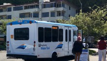 Riders of the King County Water Taxi board a free DART shuttle near Seacrest Park in West Seattle.