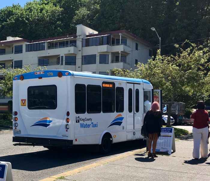 Riders of the King County Water Taxi board a free DART shuttle near Seacrest Park in West Seattle.