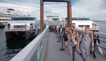 Riders disembark from the MV Doc Maynard on the Seattle waterfront, with the MV Sally Fox positioned on the opposite side of the float.