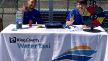 Interns for King County Water Taxi take a break to snap a picture while working the table on the Seattle waterfront.