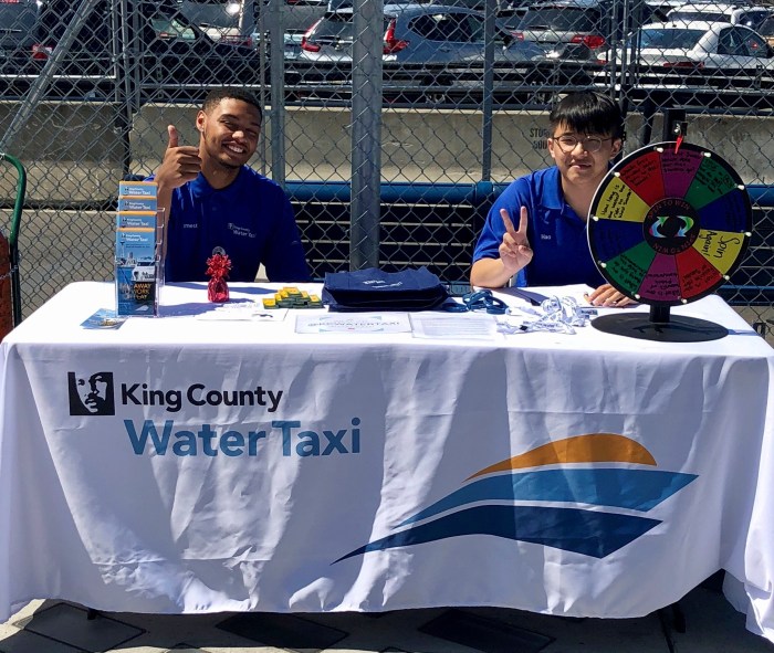 Interns for King County Water Taxi take a break to snap a picture while working the table on the Seattle waterfront.