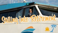 Capt. Dan Krehbiel leaning out of the wheelhouse of the M/V Sally Fox with the banner "sailing into retirement" below