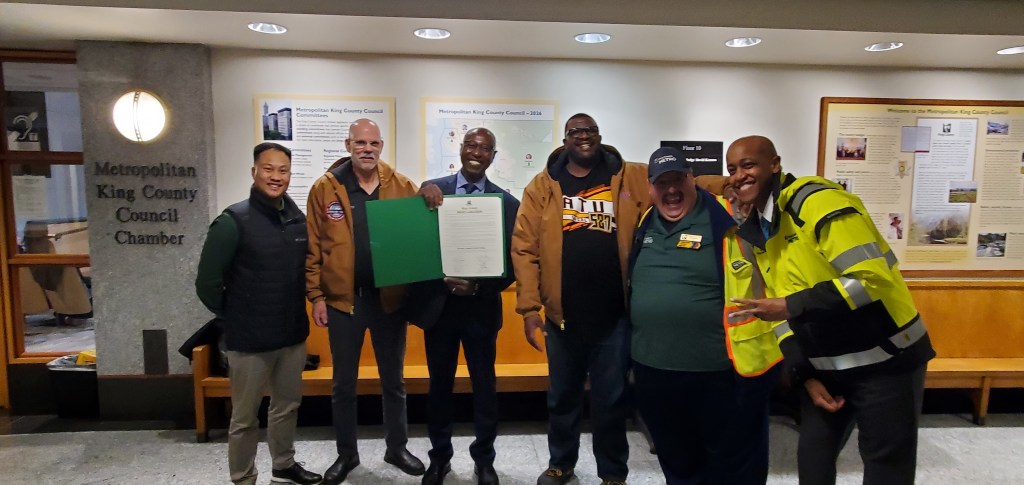 Metro Deputy General Manager Ernest Kandilige, holding the Transit Appreciation Week proclamation is joined by County Executive Girmay Zahilay, Amalgamated Transit Union (ATU) 587 Leadership and Transit Operator of the Year Jack Millman (l-r) Justin Umagat, APTA Leadership Class of 2025, Greg Woodfill, ATU President, Ernest Kandilige, ATU 587 Recording Secretary Latrell Gibson, Transit Operator of the Year Jack Millman and County Executive Girmay Zahilay